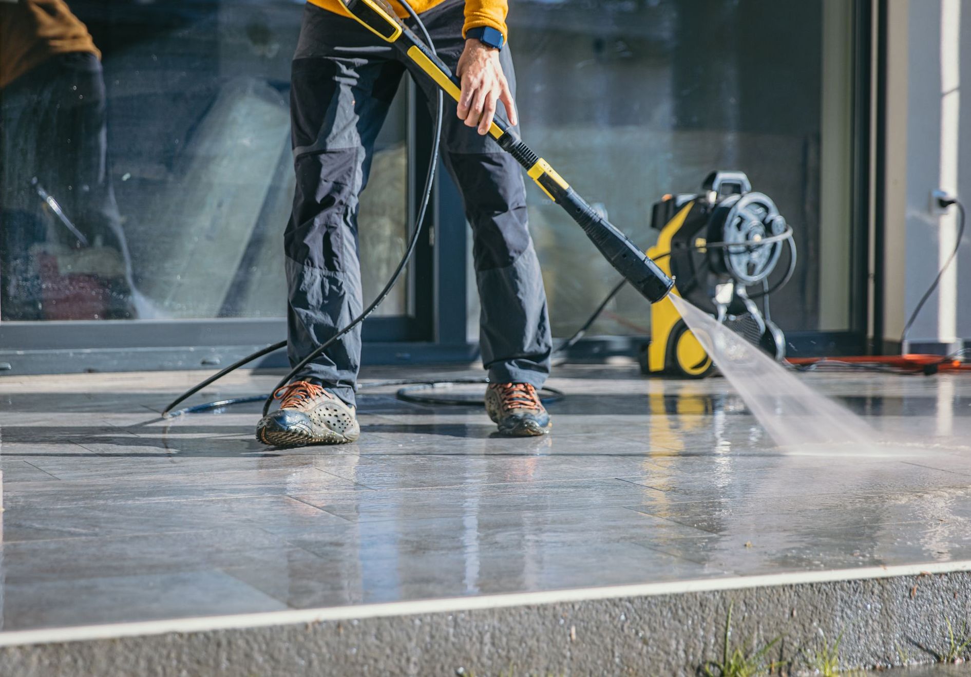 an employee from triangles best pressure washing cleans an entrance to a commercial building in north carolina